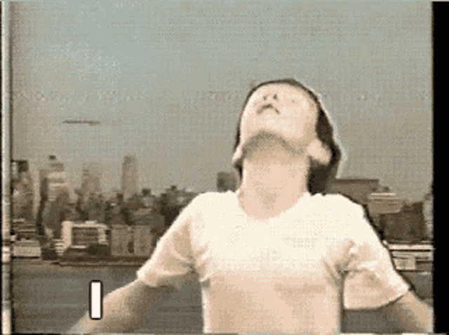 a man in a white shirt is looking up at the sky with the number 1 in the corner