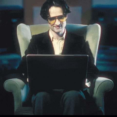 a man is sitting in a chair with a laptop that says oops on it