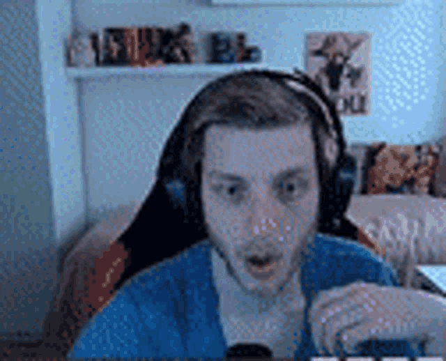 a man wearing headphones and a blue shirt is sitting in a chair .