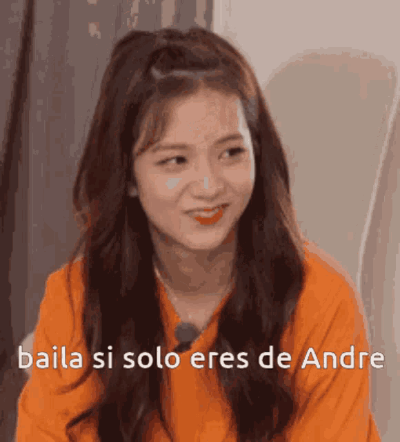 a girl in an orange shirt is making a funny face and says baila si solo eres de andre