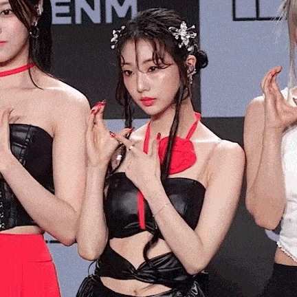 a woman wearing a black crop top with a red bow around her neck