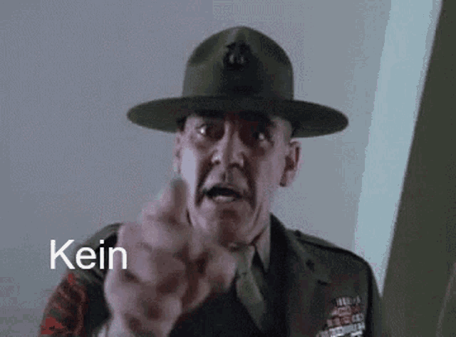 a man in a military uniform is pointing at the camera with the word kein in the corner .