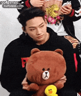 a man is holding a teddy bear and a yellow duck .