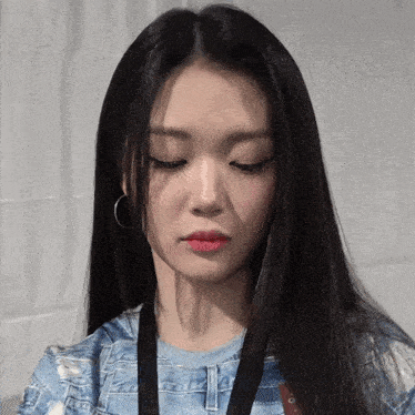 a woman with long black hair has a lanyard around her neck