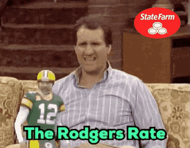 a man sitting on a couch with a green bay packers jersey on his chest