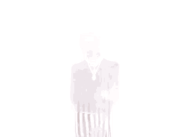 a man wearing a black turtleneck and striped pants is standing in front of a white wall smoking a cigar