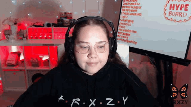 a woman wearing headphones is sitting in front of a white board that says hype board on it