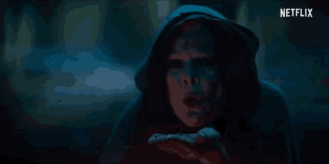 a person is standing in a dark room with smoke coming out of their mouth and a netflix logo in the corner .