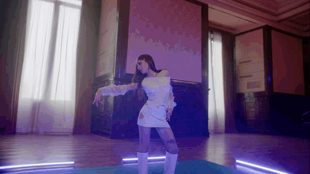 a woman in a white dress and white boots is dancing