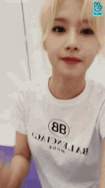 a woman wearing a white t-shirt that says " balenciaga "