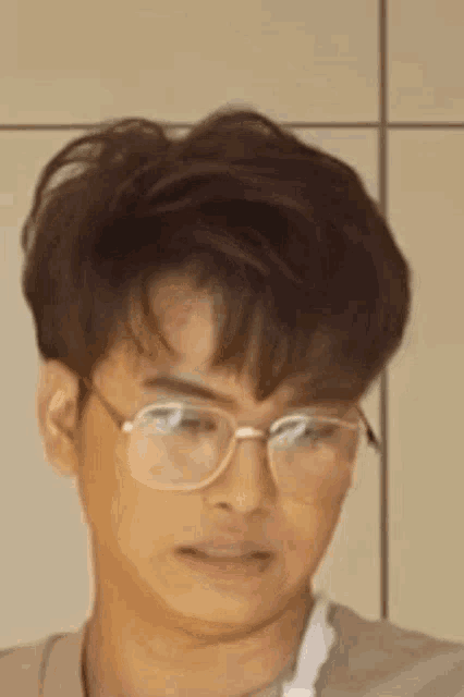 a close up of a man wearing glasses and making a funny face .