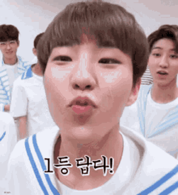 a boy with korean writing on his face making a face