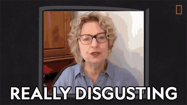 a woman wearing glasses says really disgusting in front of a television screen