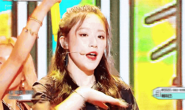a girl is singing into a microphone on a stage while dancing .