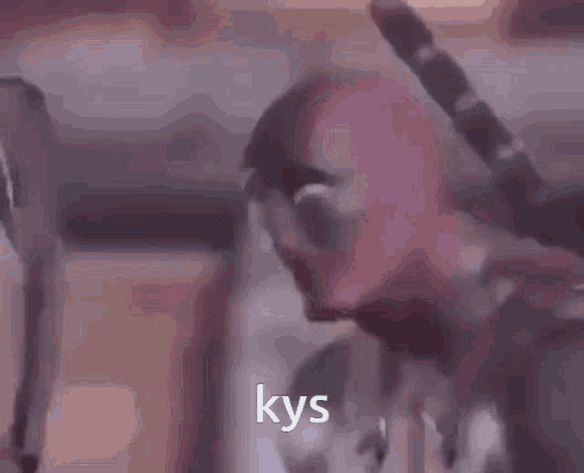 a blurred image of a person with the word kys in white