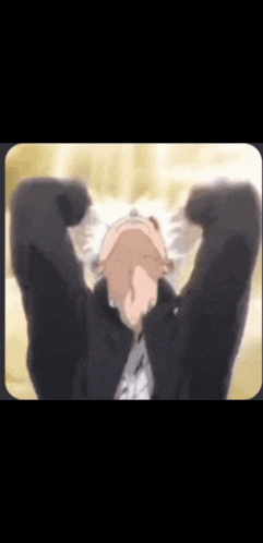 a man in a black jacket is covering his face with his hands and looking up .