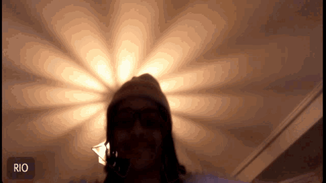 a person 's head is visible in front of a light with the word rio below it