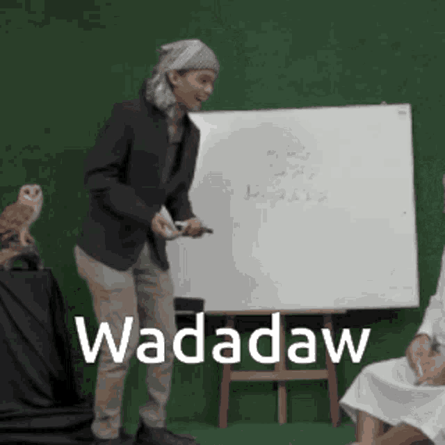 a man is standing in front of a white board with the word wadadaw written on it
