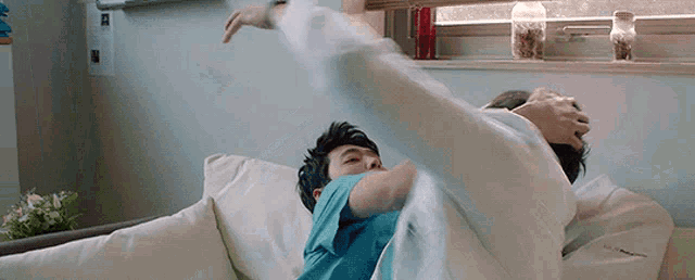 a man and a woman are laying on a couch in a hospital bed .