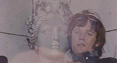 a man standing next to a statue with a crown on his head