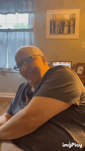 a man wearing glasses and a t-shirt that says " each day ever after " smiles