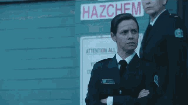 two female police officers stand in front of a hazchem sign