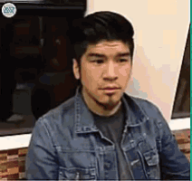 a man wearing a denim jacket and a black shirt