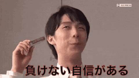 a man in a white shirt is holding a stick in his hand and making a funny face .