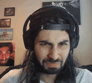 a man with long hair and a beard wearing headphones .
