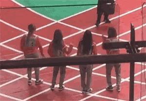 a group of young women are standing on a track .