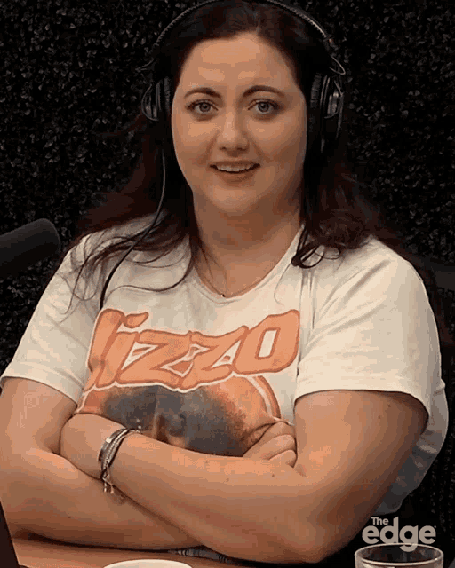 a woman wearing headphones and a t-shirt that says ' izzo ' on it