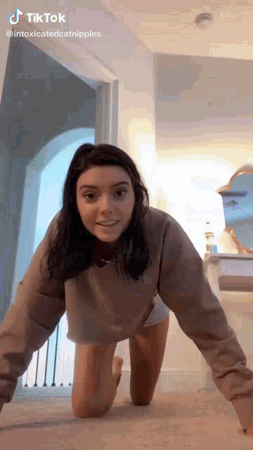 a woman is crawling on her knees in a room with a tiktok watermark