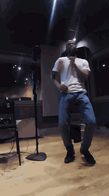 a man in a white shirt and blue jeans is dancing