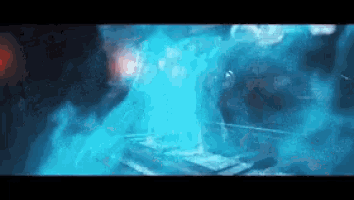 a person is standing in a dark room with a blue light coming out of the ceiling .