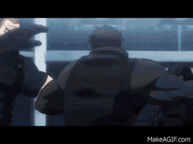 a couple of men are standing next to each other in a room and fighting .
