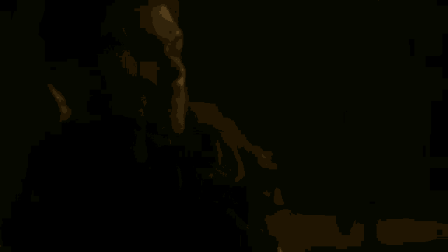 a man is sitting in a dark room with candles .