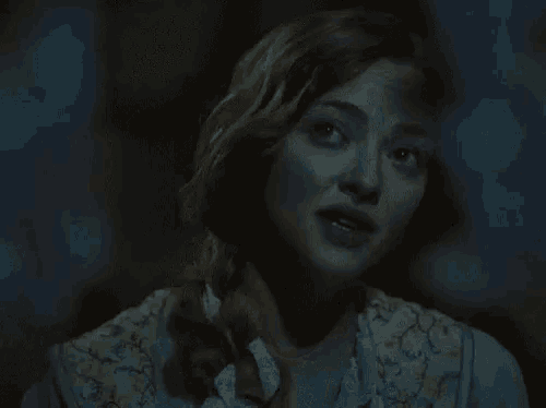 a close up of a woman 's face in the dark with a braid .