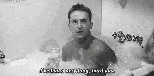 a shirtless man is taking a bath with a glass of wine and says i 've had a very long hard day