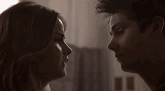 a man and a woman are looking at each other with their eyes closed .
