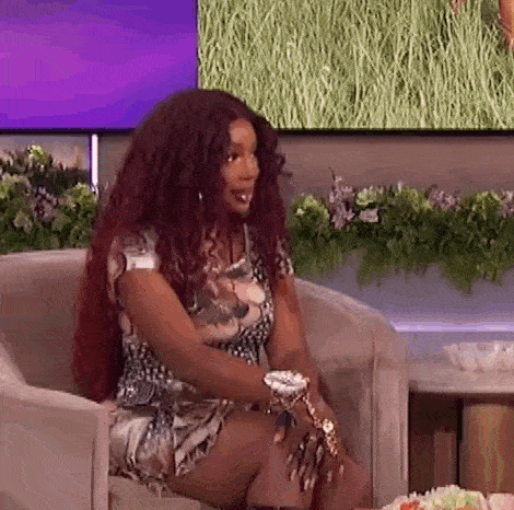 a woman with long red hair is sitting in a chair on a show .