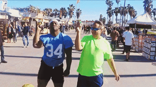 a man in a blue jersey with the number 34 on it stands next to another man in a neon green shirt
