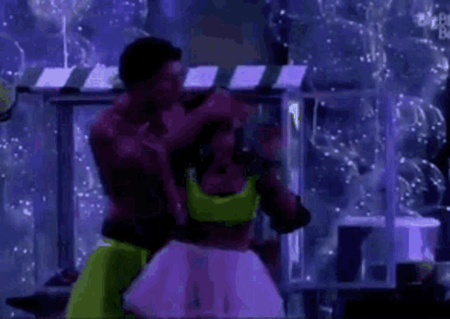 a man and a woman are dancing in a room with bubbles in the background .