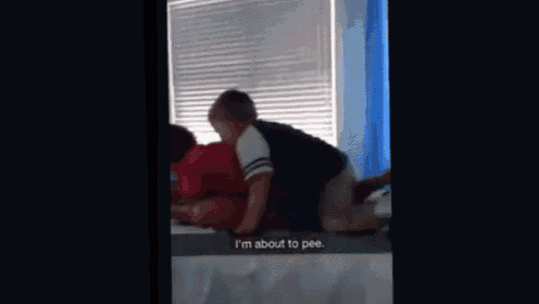 a person is laying on a bed with a caption that says i 'm about to pee