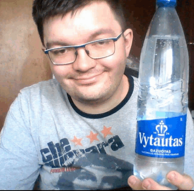 a man holds a bottle of vytautas water in his hand