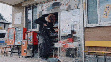a man is standing in front of a store with a sign that says ' ae ' on it