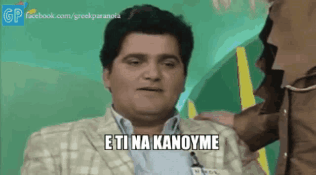 a man in a suit says " eti na kanoyme " in greek