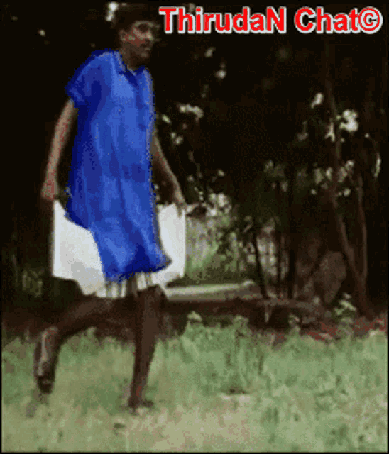 a man in a blue dress is walking in a field with the words thiruda n chat written above him