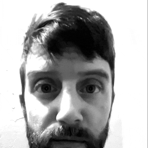 a man with a beard looks at the camera with a surprised look on his face