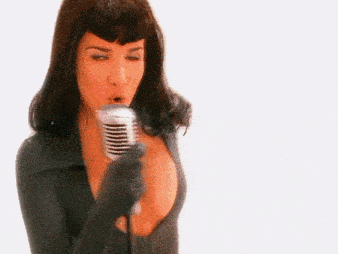 a woman singing into a microphone with her mouth open .