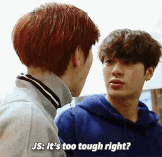 two young men are standing next to each other and one of them is asking the other if it is too tough right .